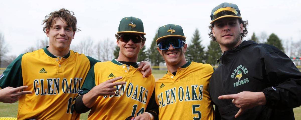 Four baseball players in their baseball uniforms, standing side by side.