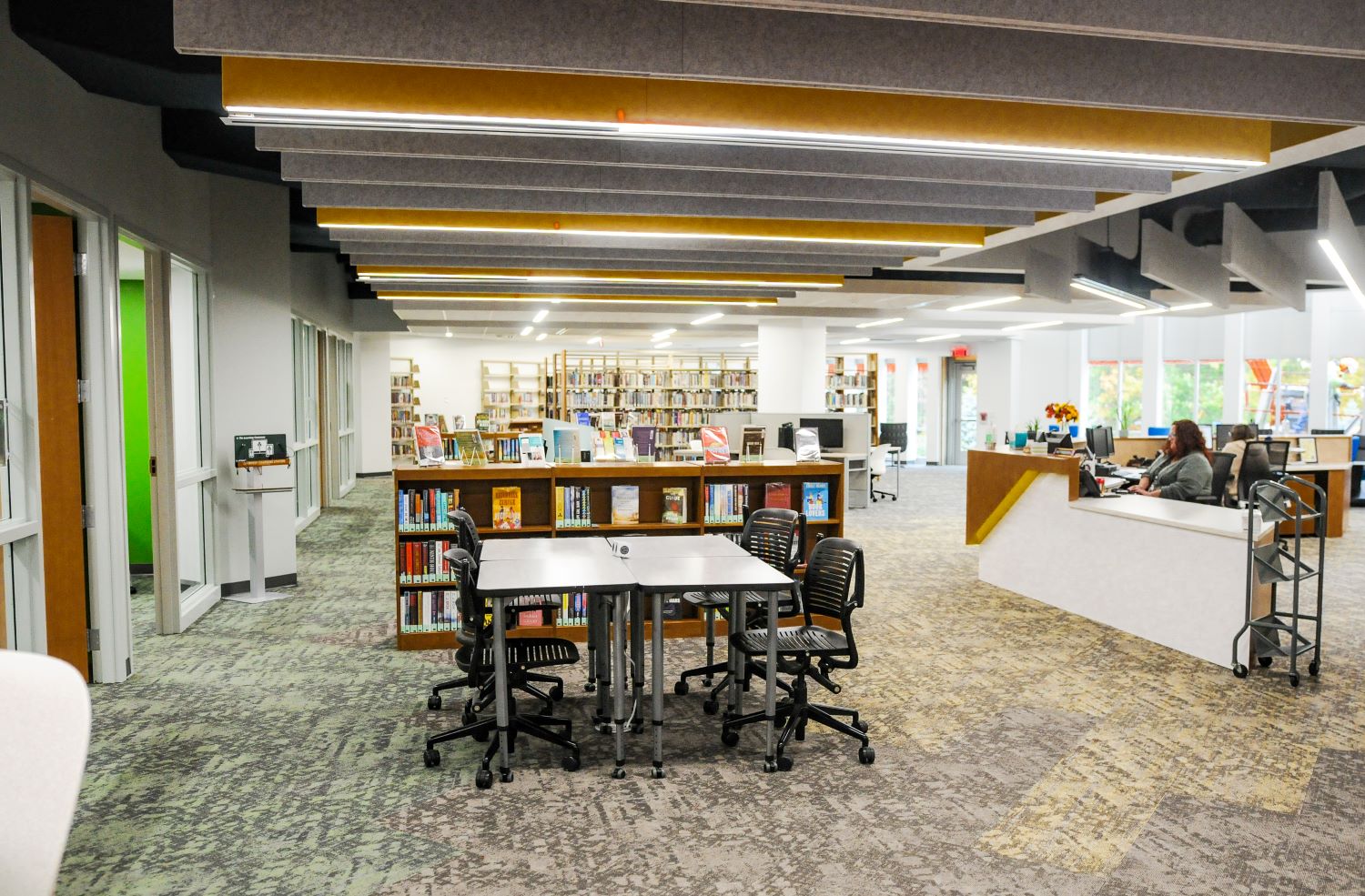 Overview photo of the Learning Commons showing different table setups, bookcases, and study rooms