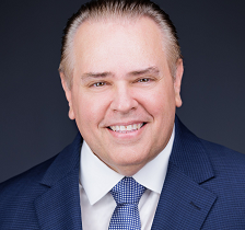 Headshot of Dr. Brian Newton in a blue suit and white shirt and blue tie.