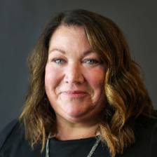 Head shot of Tonya Howden wearing a black dress and silver necklace.