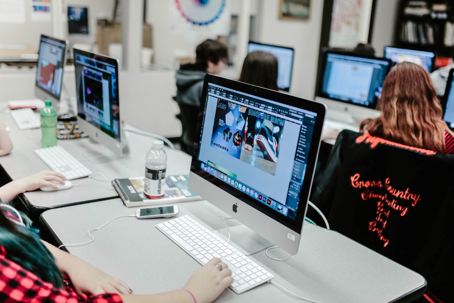 Students seated in front of computers in graphic design class