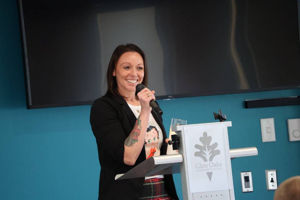 female student holding a microphone and standing in front of a podium