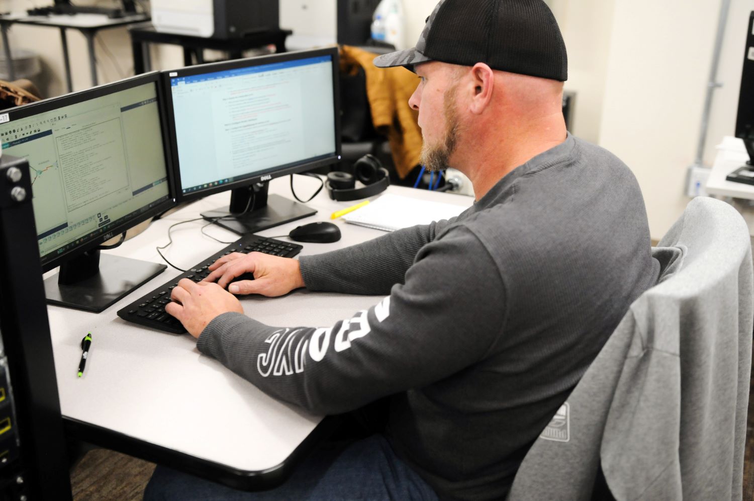 Male Student sitting in front of computer monitors 