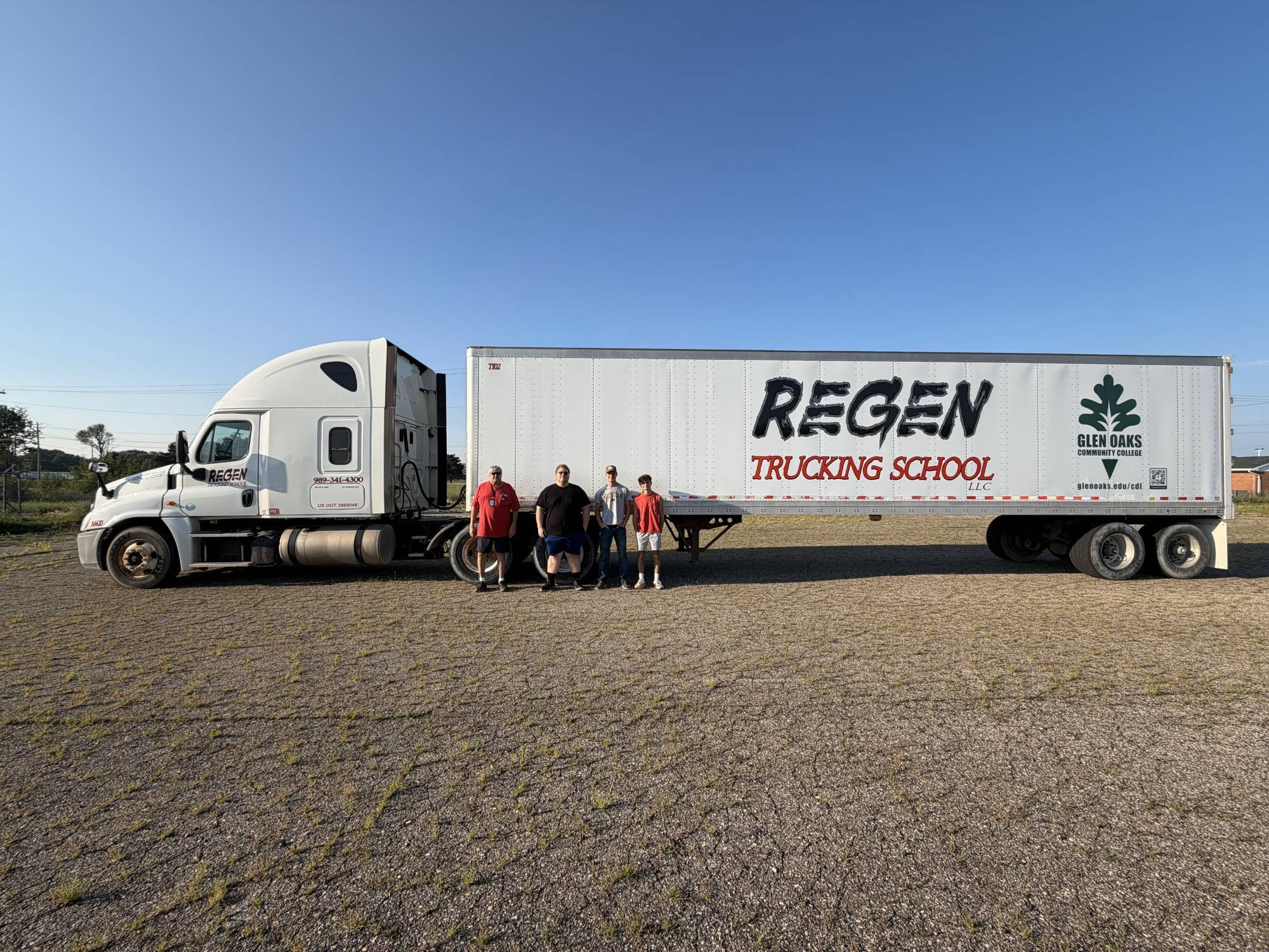 Semi truck with three students standing in front of it