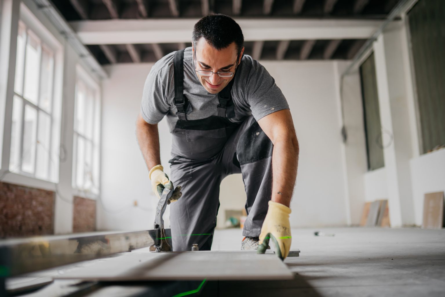 man in residential home construction installing flooring