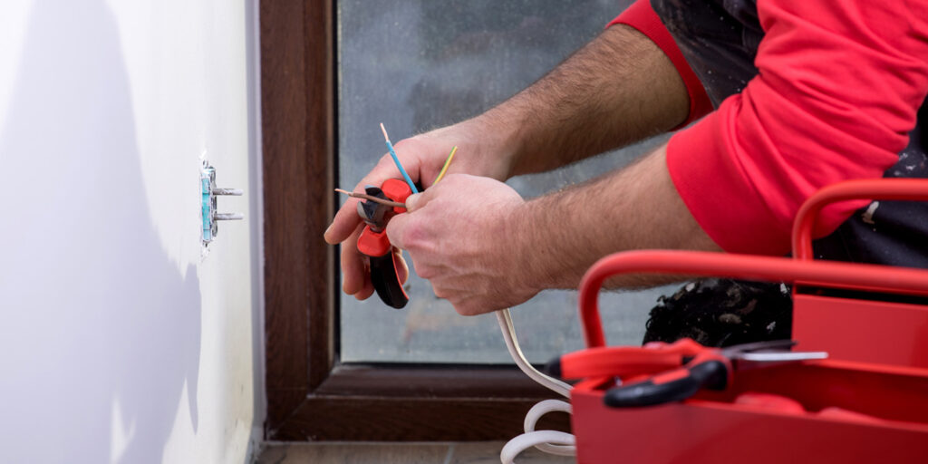image of a man's hands holding electrical equipment